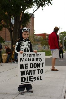  A child, dressed as a skeleton, holding a placard.