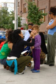  A young girl gets her face painted while waiting for the Human Train to arrive.